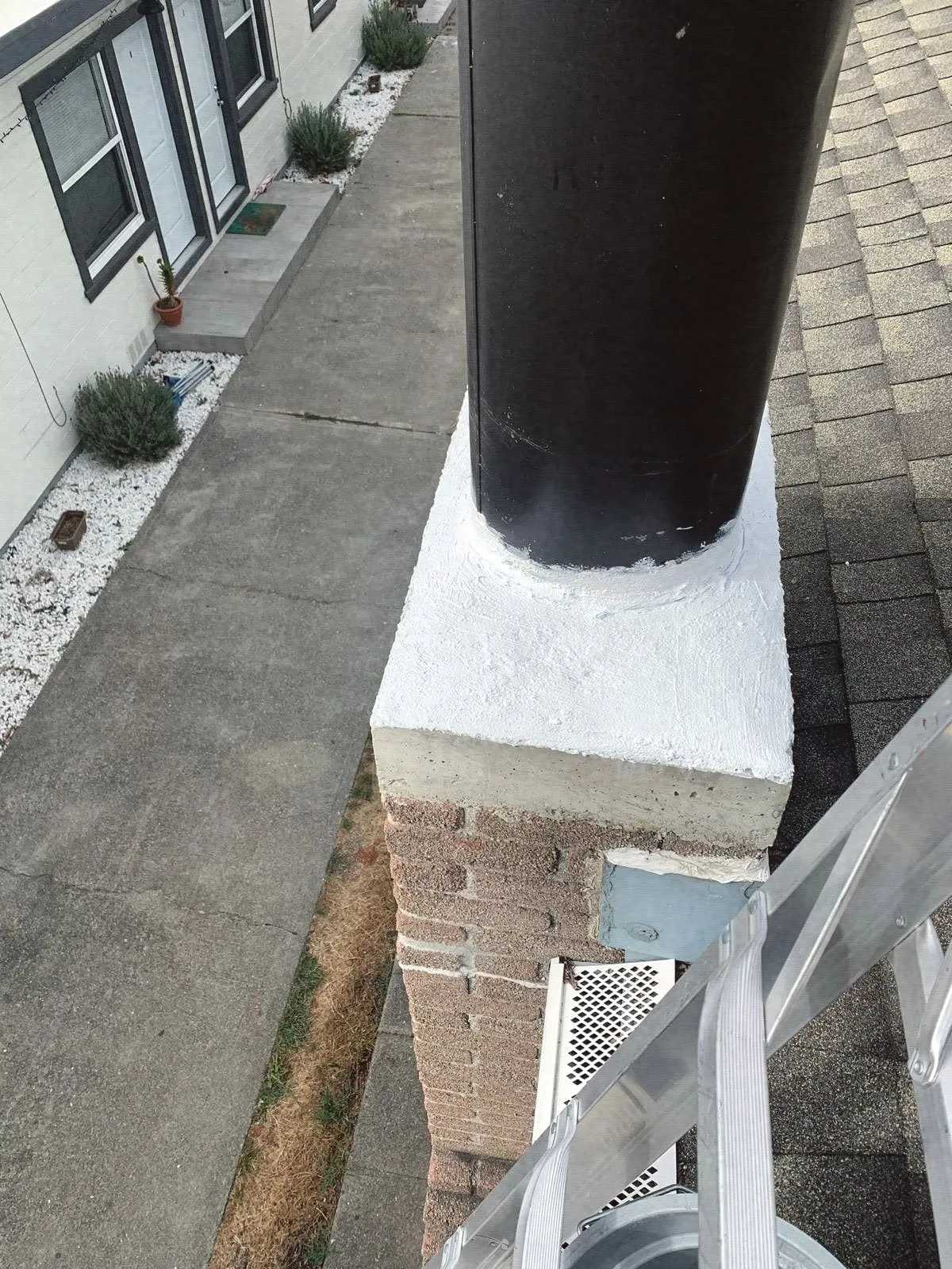 A black stove pipe rising through a white chase top